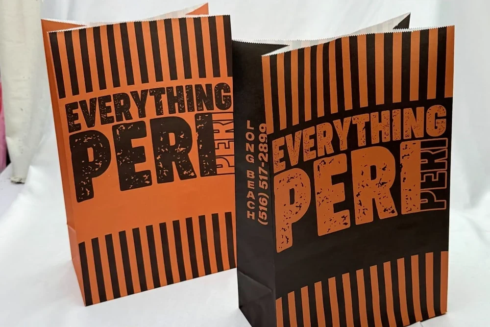 Two Peri-Peri Guys branded paper bags